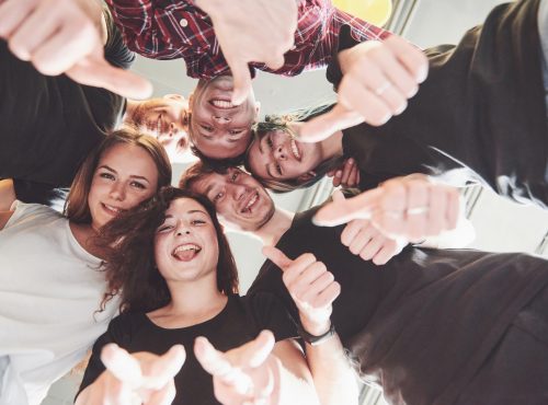 Happy group of friends with their hands together in the middle.