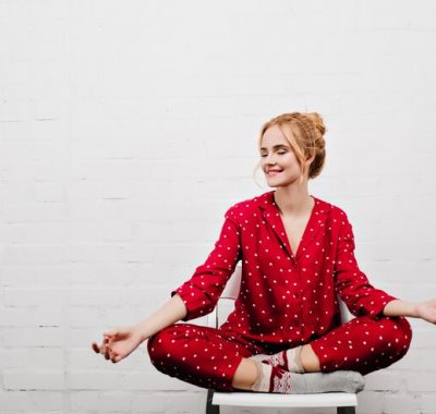 pleased-girl-red-pajamas-doing-yoga-white-wall-indoor-portrait-blonde-young-lady-sitting-lotus-pose-chair_197531-21744