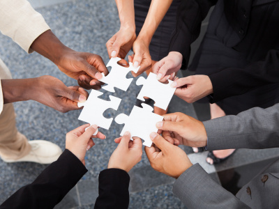 Close-up Photo Of Businesspeople Holding Jigsaw Puzzle